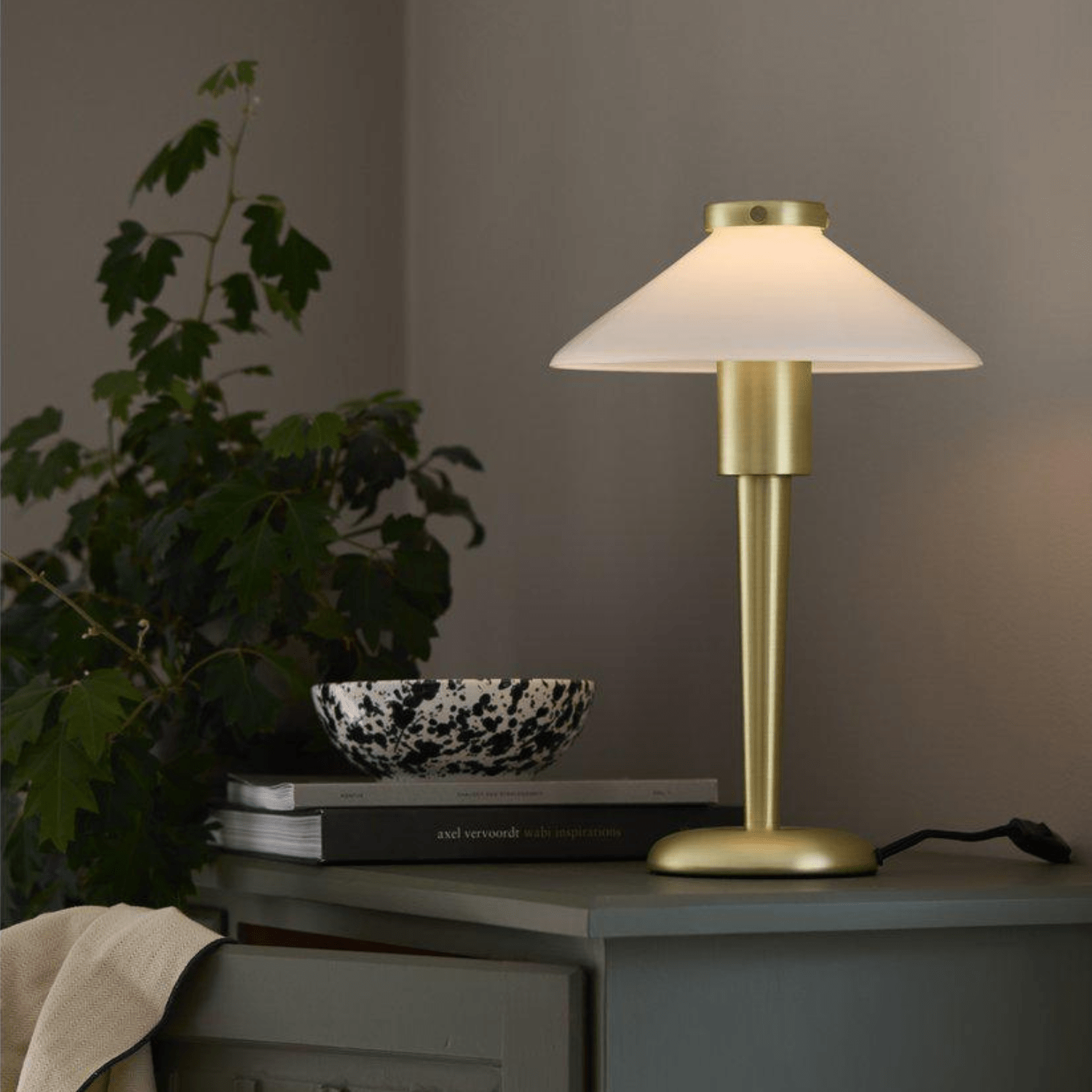 Elegante gouden tafellamp met een witte kap, perfect voor een luxe en moderne interieurstijl.